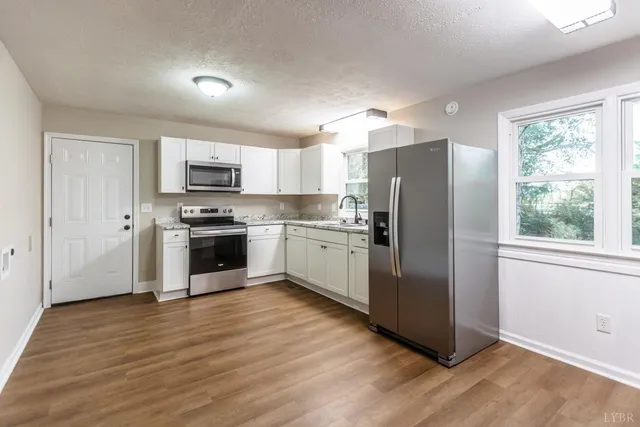 a kitchen with stainless steel appliances a refrigerator sink and microwave