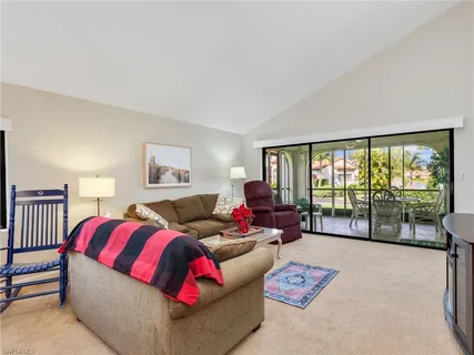 a living room with furniture and a large window with balcony view