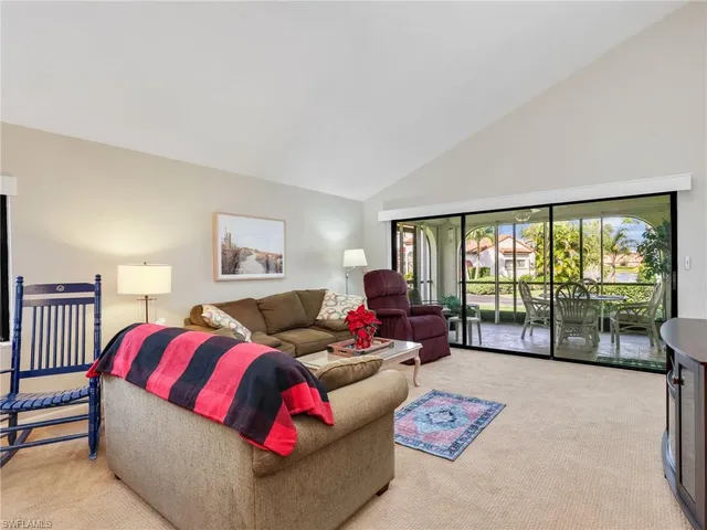 a living room with furniture and a large window with balcony view
