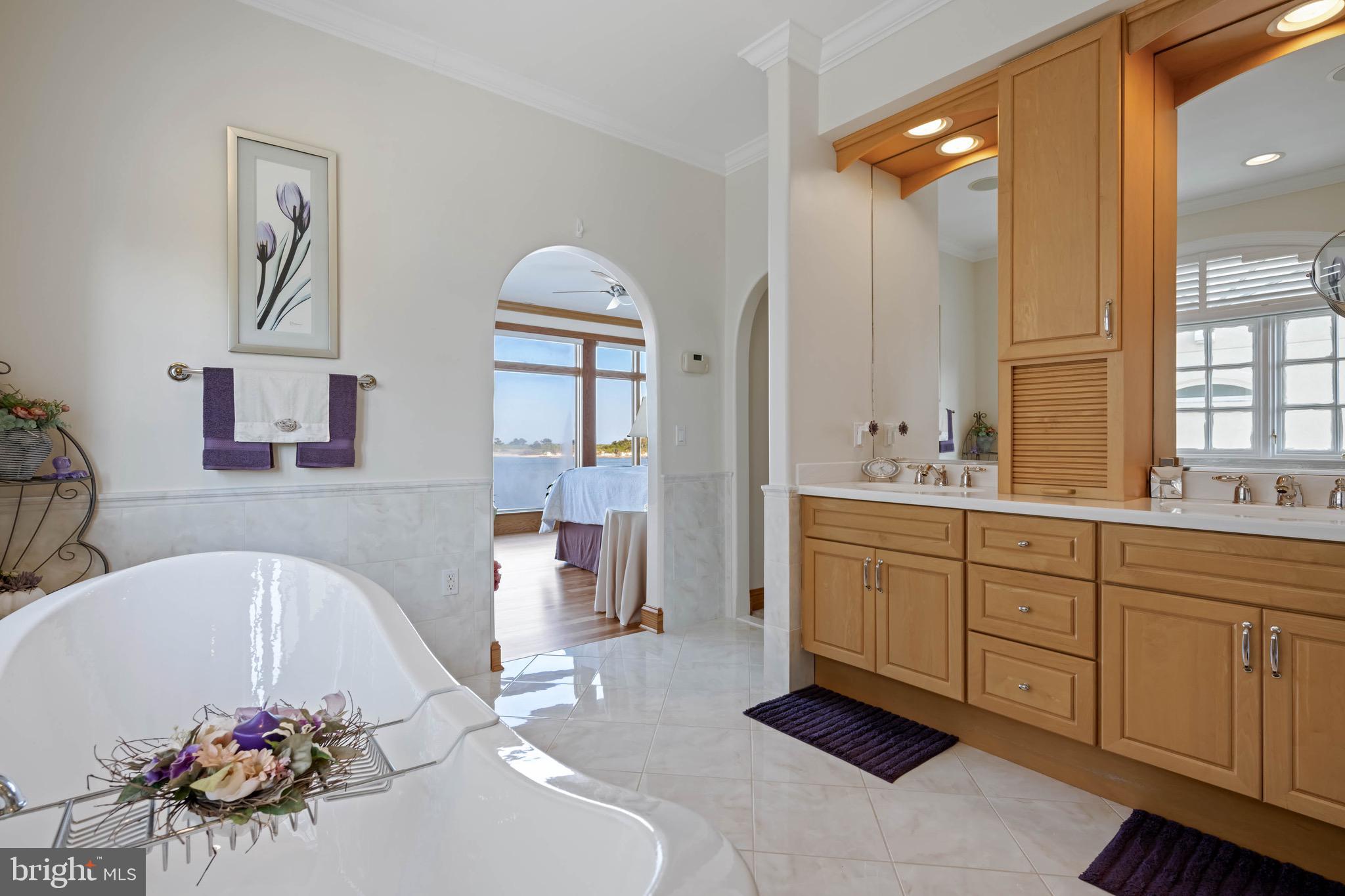 12959 Harbor Road Ocean City, MD 21842 - Photo 28 of 85 a spacious bathroom with a tub sink and mirror