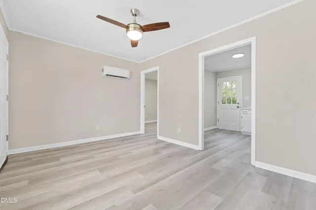 an empty room with fan and entrance