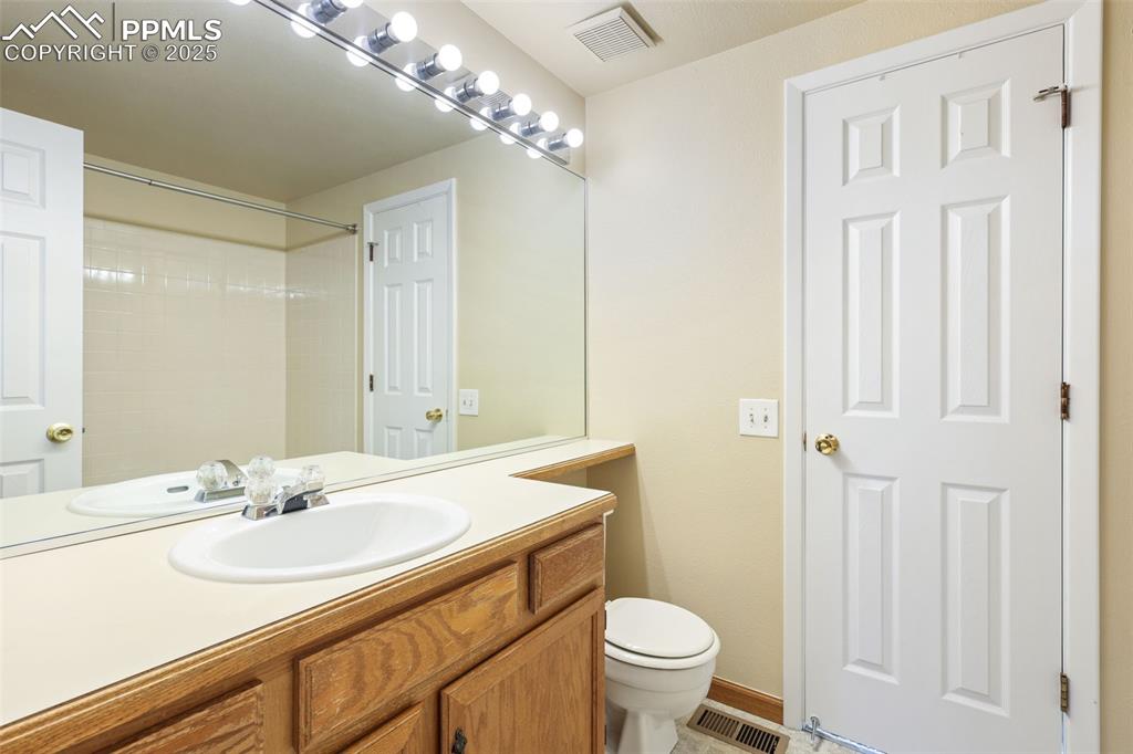 2575 Hatch Circle Colorado Springs, CO 80918 - Photo 21 of 39 a bathroom with a granite countertop sink a toilet and a mirror