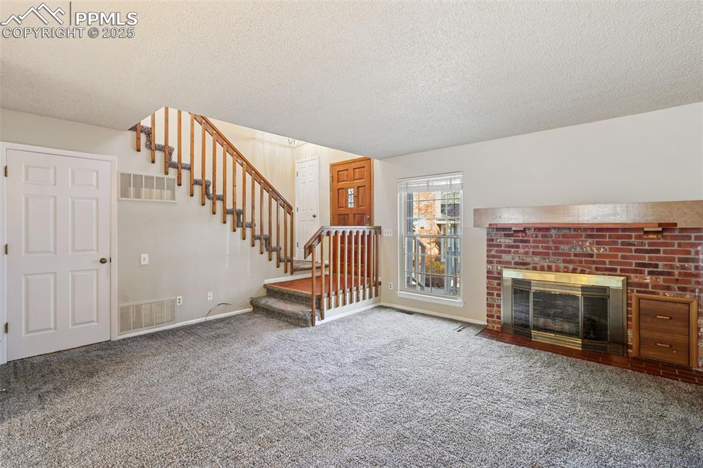 2575 Hatch Circle Colorado Springs, CO 80918 - Photo 4 of 39 a view of an empty room with fireplace stairs and windows