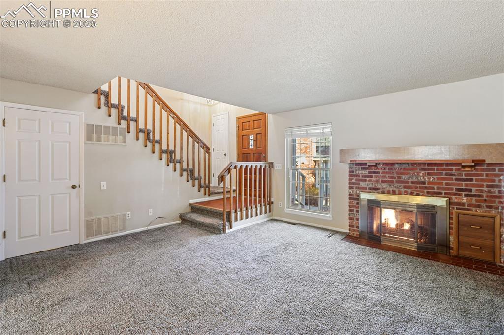 2575 Hatch Circle Colorado Springs, CO 80918 - Photo 5 of 39 a view of livingroom with fireplace and stairs