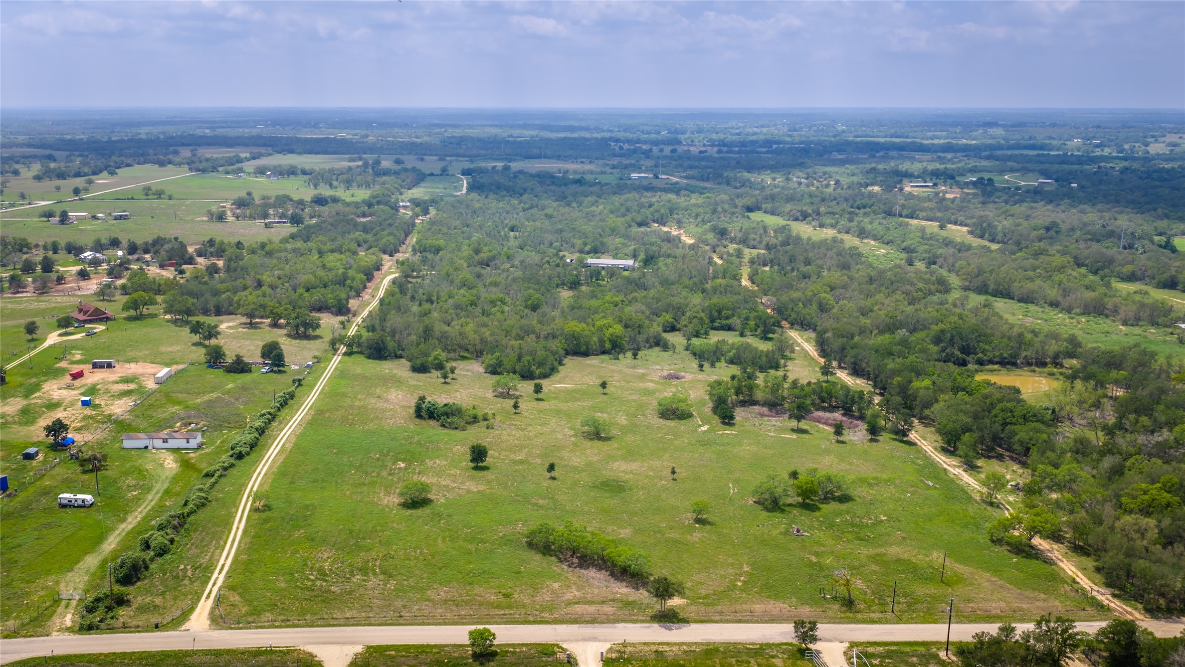 4082 Old Colony Line Road Lockhart, TX 78644 - Photo 26 of 40 Acres of verdant land await, featuring a mix of open fields and mature woodlands for diverse use.