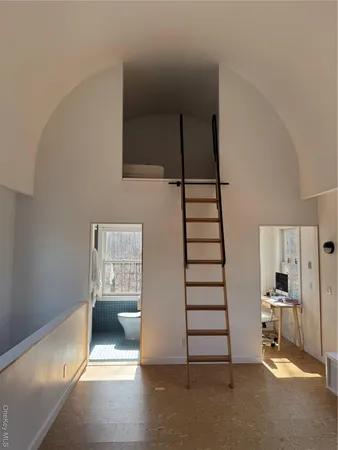 a view of a hallway with stairs and furniture