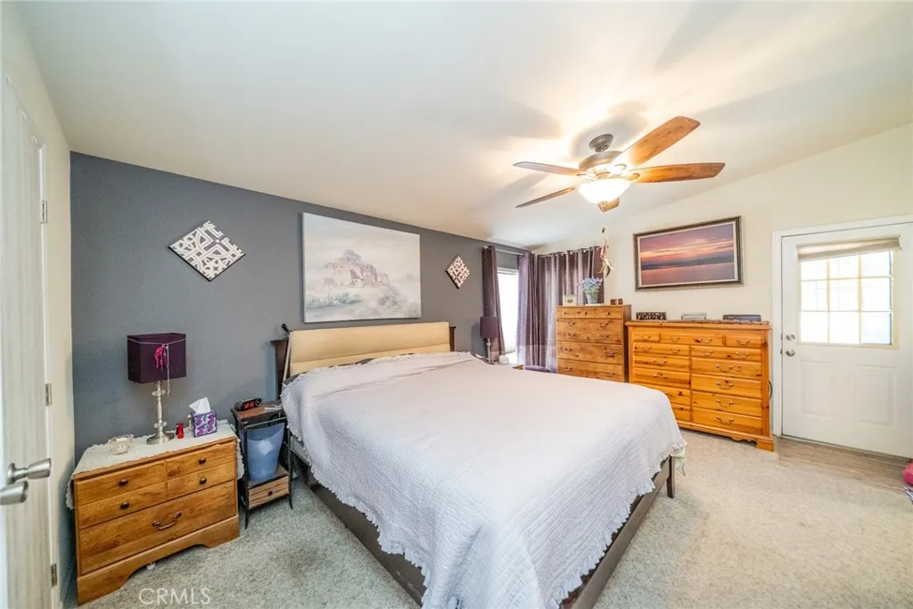 22241 Nisqually Road, Unit 153 Apple Valley, CA 92307 - Photo 18 of 55 a bedroom with a bed and a chandelier