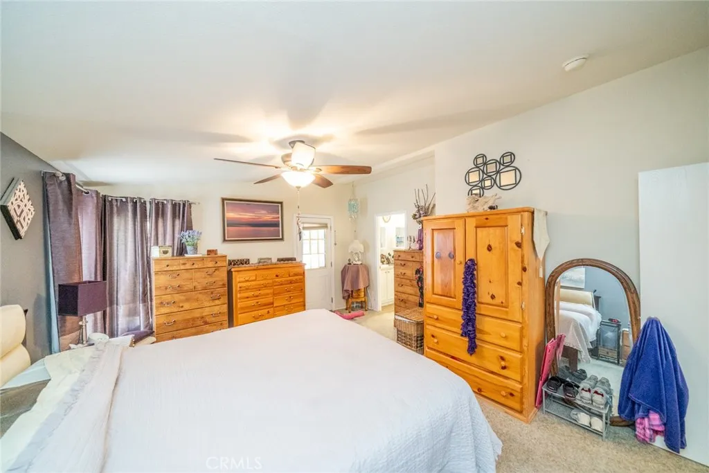 22241 Nisqually Road, Unit 153 Apple Valley, CA 92307 - Photo 19 of 55 a bedroom with a bed and a chandelier