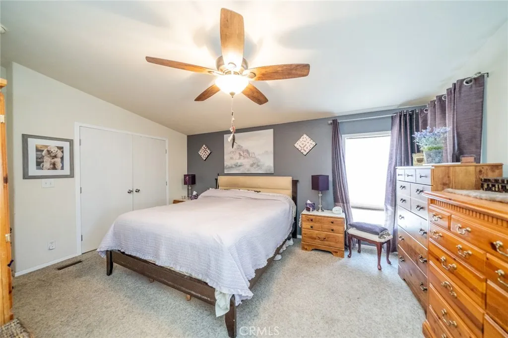 22241 Nisqually Road, Unit 153 Apple Valley, CA 92307 - Photo 20 of 55 a bedroom with a bed and a chandelier