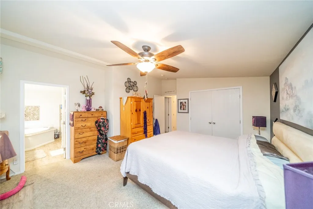 22241 Nisqually Road, Unit 153 Apple Valley, CA 92307 - Photo 21 of 55 a bedroom with a bed and a large mirror on the dresser
