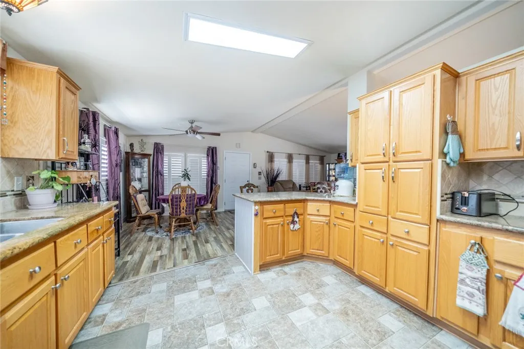 22241 Nisqually Road, Unit 153 Apple Valley, CA 92307 - Photo 7 of 55 a kitchen with granite countertop cabinets stainless steel appliances a sink and a large window