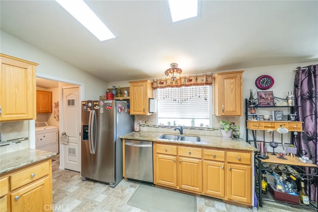 22241 Nisqually Road, Unit 153 Apple Valley, CA 92307 - Photo 8 of 55 a kitchen with refrigerator and window