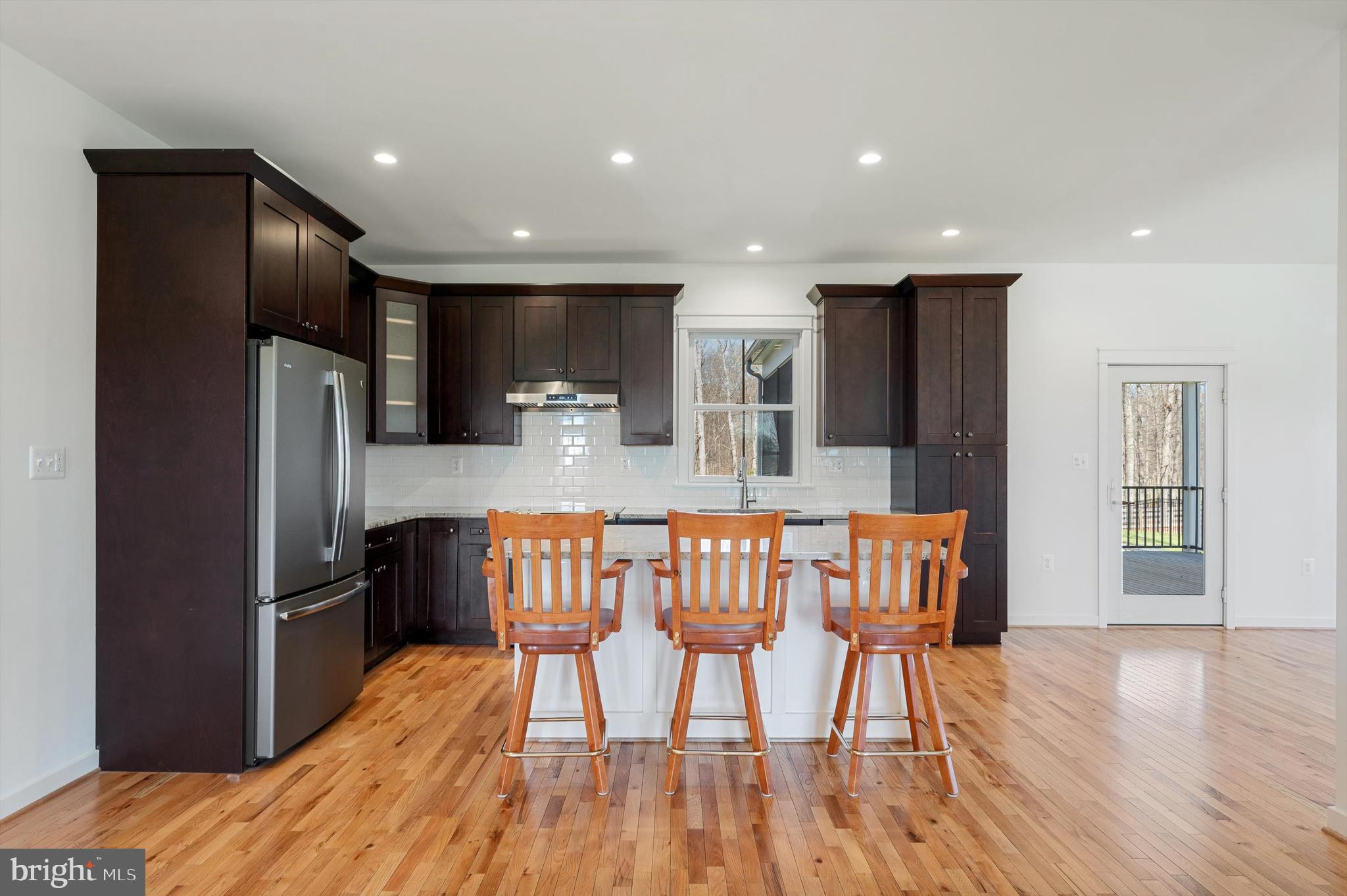 105 Loretto Drive Clear Brook, VA 22624 - Photo 16 of 65 a kitchen with stainless steel appliances kitchen island granite countertop a refrigerator a stove a sink a dining table and chairs with wooden floor