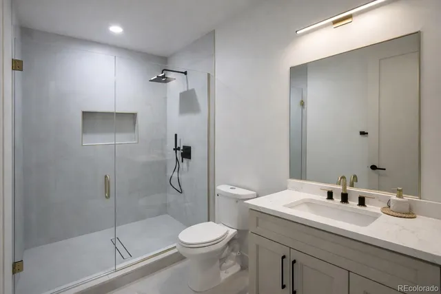 a bathroom with a sink a toilet and mirror