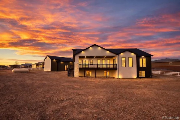 a view of a large house with large windows and a big yard