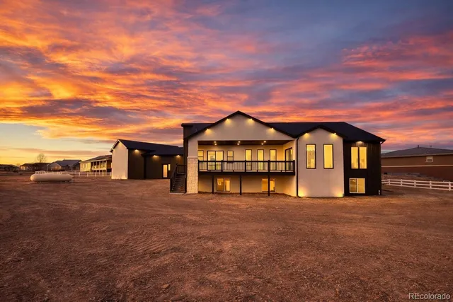 a view of a large house with large windows and a big yard