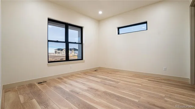 a view of a house with large trees and wooden fence