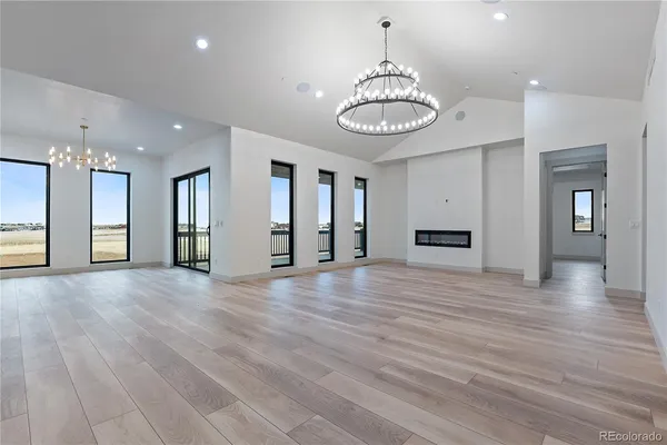 a view of a room with a chandelier and wooden floor