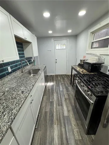 a kitchen with sink stove and cabinets