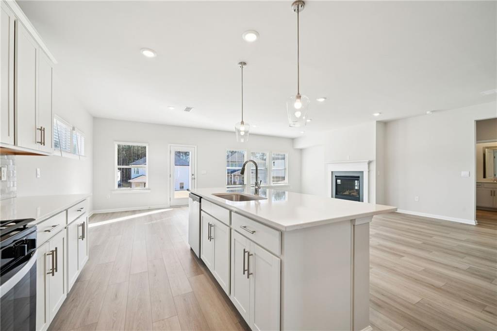 391 Tallulah Lane Grayson, GA 30017 - Photo 11 of 35 a kitchen with a sink stove and wooden floor