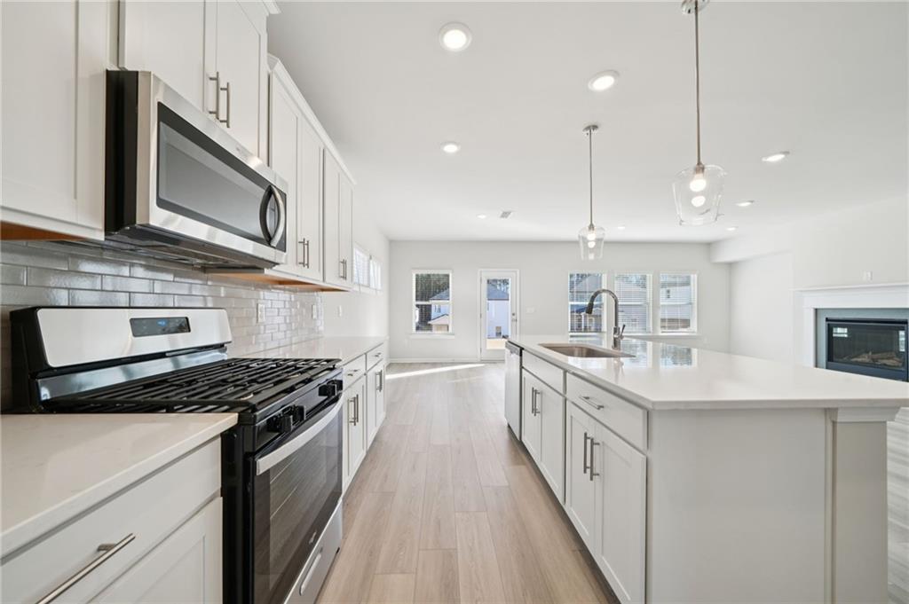 391 Tallulah Lane Grayson, GA 30017 - Photo 12 of 35 a kitchen with stainless steel appliances a sink stove and cabinets