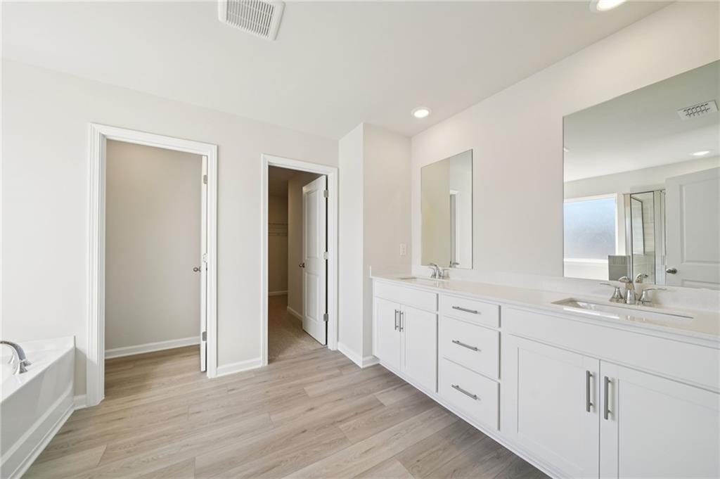 391 Tallulah Lane Grayson, GA 30017 - Photo 22 of 35 a bathroom with double vanity sink a two mirror a window and a bathtub