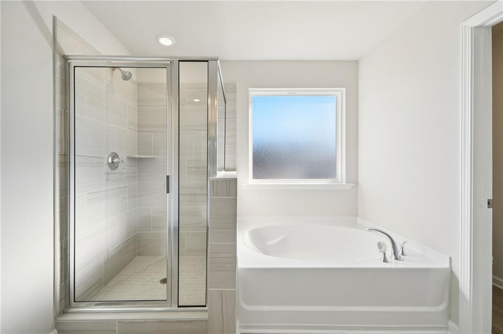 391 Tallulah Lane Grayson, GA 30017 - Photo 23 of 35 a bathroom with a bathtub and a shower