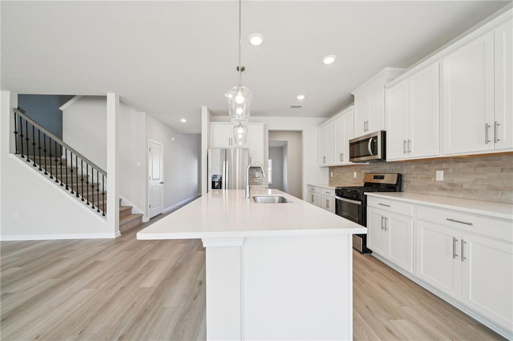 391 Tallulah Lane Grayson, GA 30017 - Photo 10 of 35 a open kitchen with kitchen island a sink stainless steel appliances and cabinets