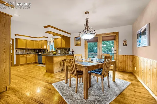 a view of a dining room and livingroom with furniture wooden floor a chandelier