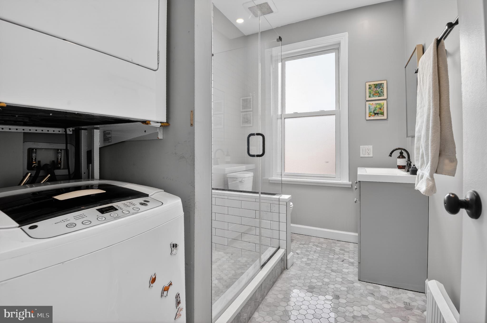 315 16th Street Southeast Washington, DC 20003 - Photo 17 of 21 a bathroom with a granite countertop sink a window and shower