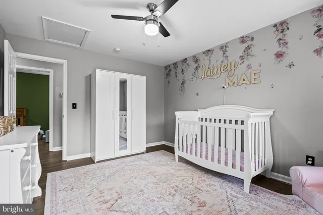 a bedroom with a baby bed a couch and a window