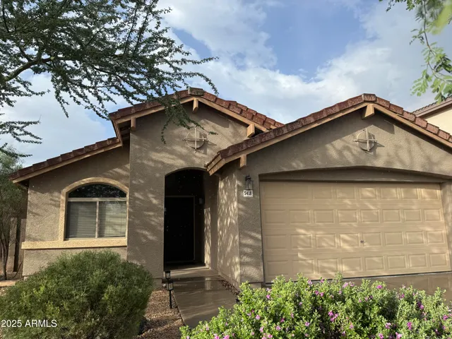 a front view of a house with plants