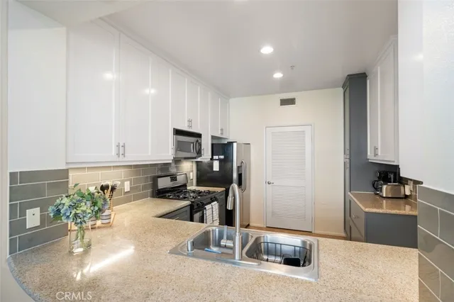 a kitchen with sink refrigerator and stove