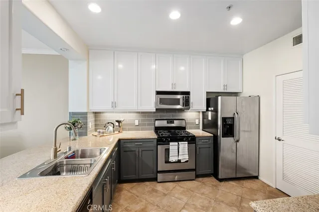 a kitchen with stainless steel appliances granite countertop a refrigerator sink and stove