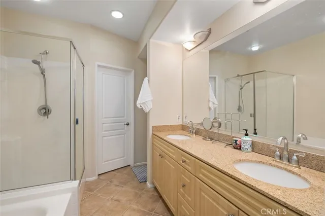 a bathroom with double vanity sinks and a shower