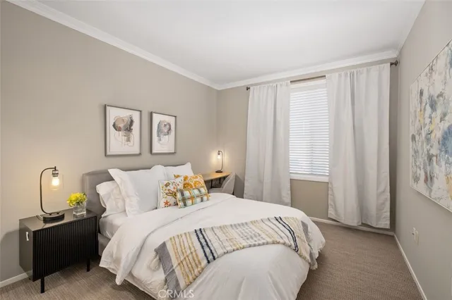 a bedroom with a bed lamp and a window