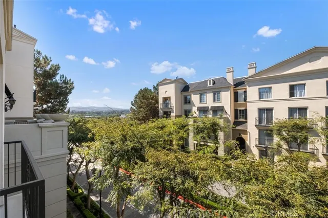 a front view of a multi story residential apartment building with yard and parking space