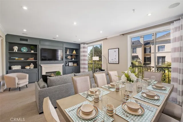 a living room with furniture a flat screen tv and kitchen view