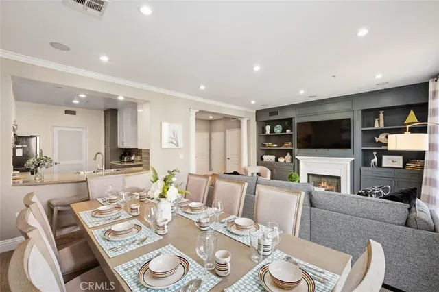 a living room with furniture a flat screen tv and kitchen view