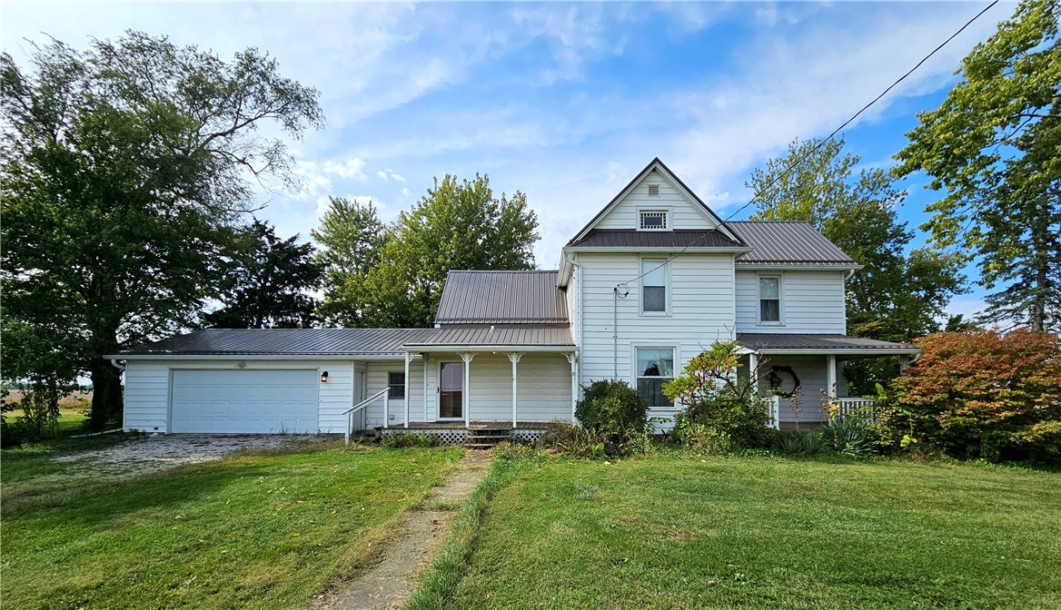 a front view of a house with a yard and trees