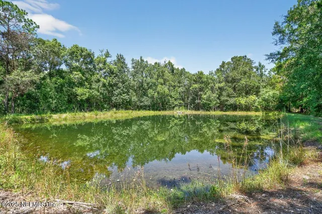 a room with stainless steel appliances furniture a large window and a kitchen view