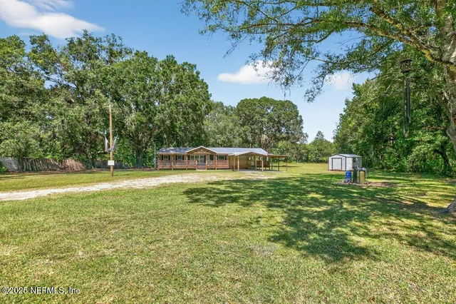 a view of a garden with a bench and a lake view