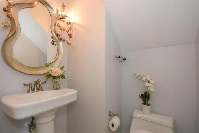 a bathroom with a sink a toilet and a mirror