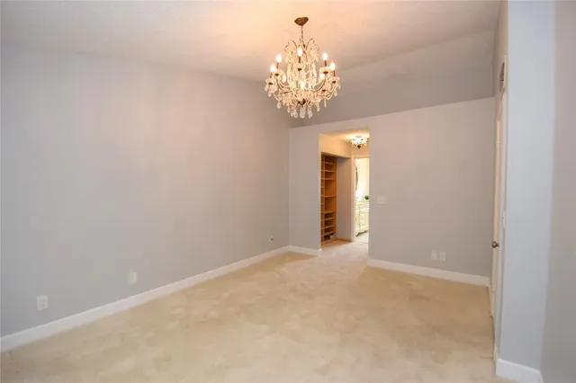a view of an empty room with chandelier