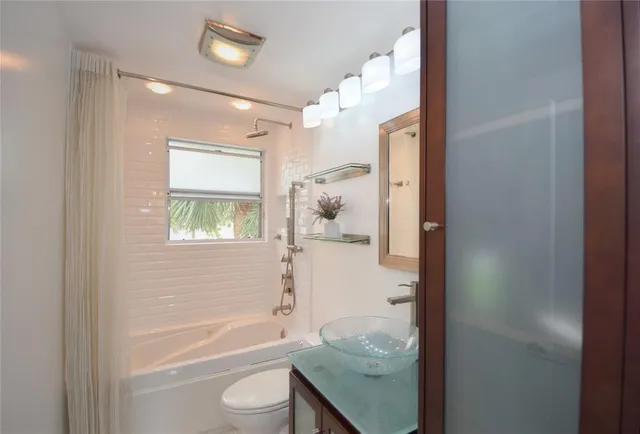 a bathroom with a granite countertop bathtub shower sink and mirror
