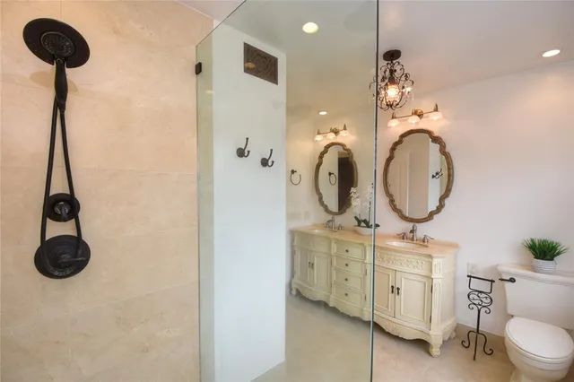 a bathroom with a granite countertop toilet sink and mirror