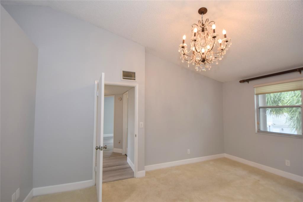 4801 Grapevine Way, Unit 4801 Davie, FL 33331 - Photo 7 of 38 an empty room with a chandelier fan and wooden floor