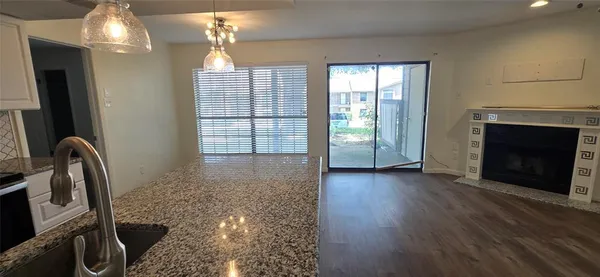 a view of a livingroom with wooden floor and a fireplace