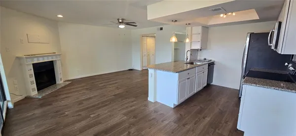 a kitchen with granite countertop a sink and a stove top oven