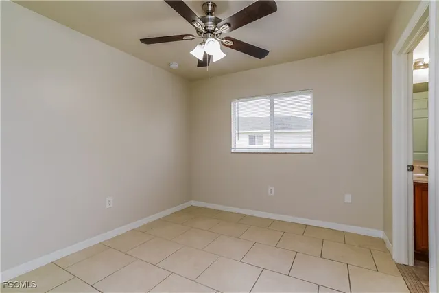 a view of an empty room and chandelier fan